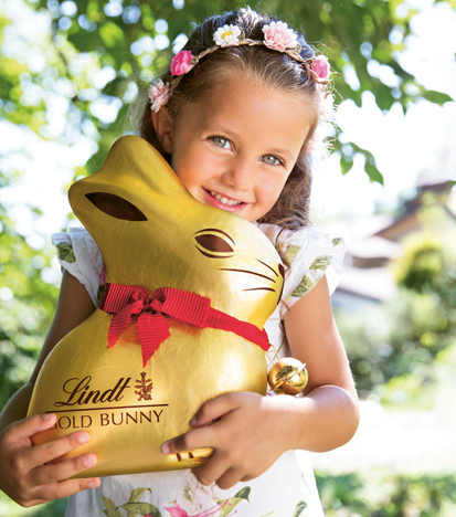 A girl is holding a big Gold Bunny. (Photo)