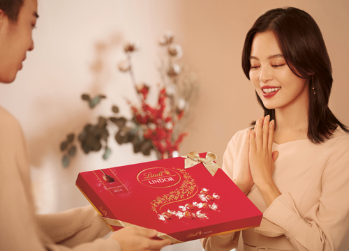 A woman receiving a box with Lindor chocolate (Photo)