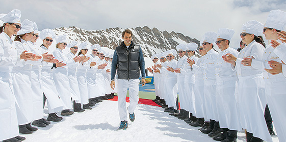 Roger Federer is walking through a line that is formed by Maitres Chocolatiers (Photo)