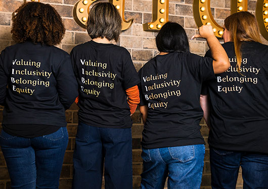 Four people wearing VIBE shirts (Photo)