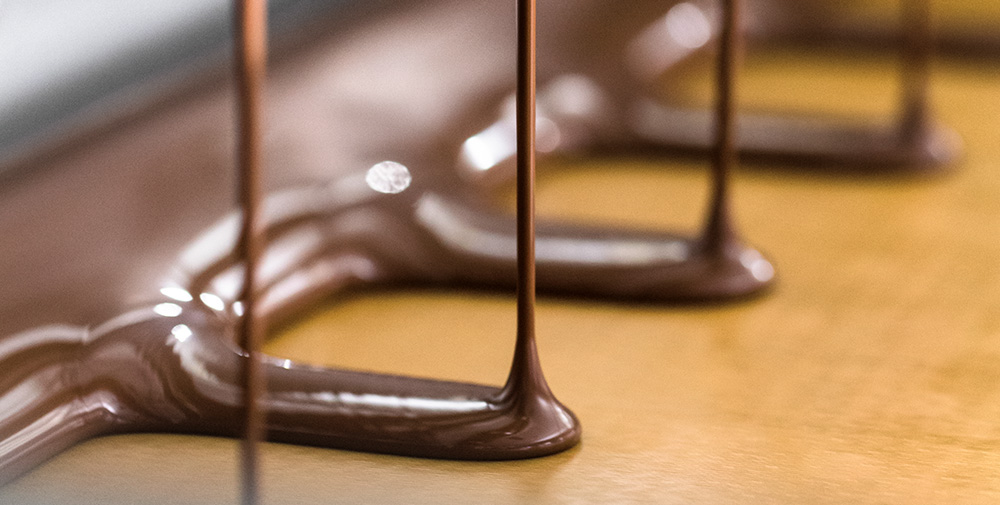 chocolate at a factory pourting onto a sheet (Photo)