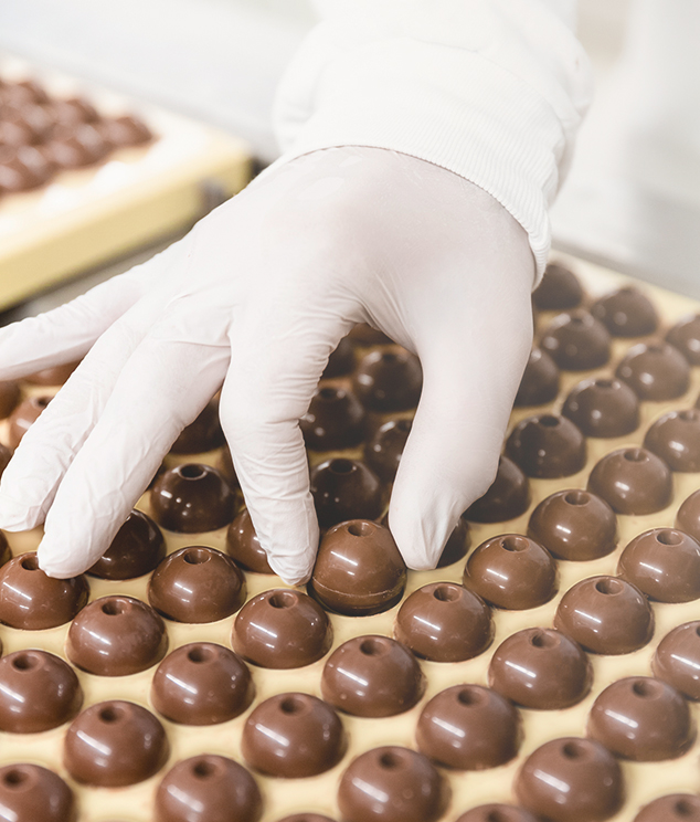 Gloved hand removing chocolate from a mold (Photo)